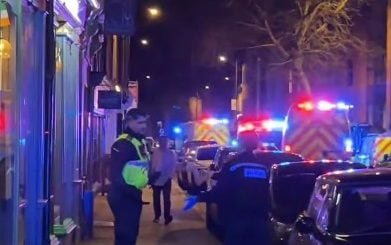 A photo of a car in the middle of a pedestrianised area in Derby city centre, with people surrounding the vehicle and emergency services attending the scene, highlighting the importance of pedestrian safety and responsible driver behaviour