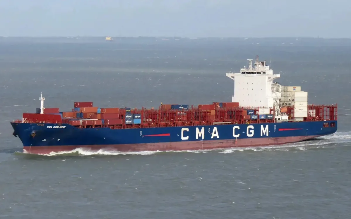 A French ship sailing through the Strait of Hormuz, with the Iranian coastline in the background, symbolising cooperation and stability in the region, a vital shipping lane for global oil trade