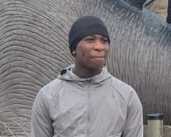 A sombre image of a residential street in south-east London, with a police cordon in place, following the fatal shooting of a 14-year-old boy, with a focus on community safety and the investigation into the incident
