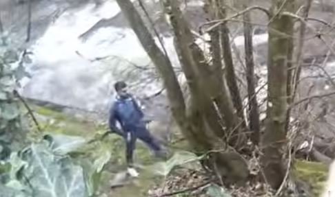 A man clinging to a rescue rope in the river, with emergency services personnel nearby, highlighting the primary keyword of river rescue in action