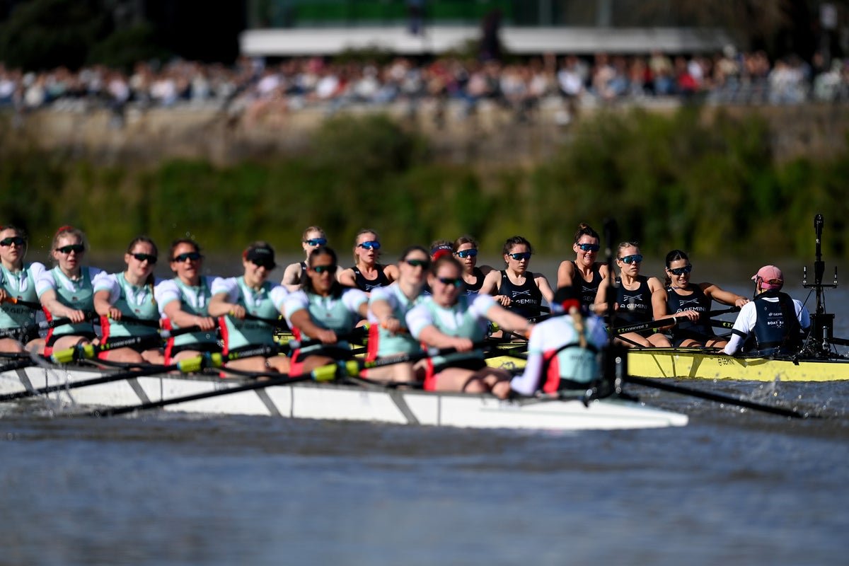 The Oxford and Cambridge boat crews in action on the River Thames, with spectators cheering them on from the riverbanks. The image captures the colour and excitement of the event, with the primary keyword 'Boat Race' prominently featured.
