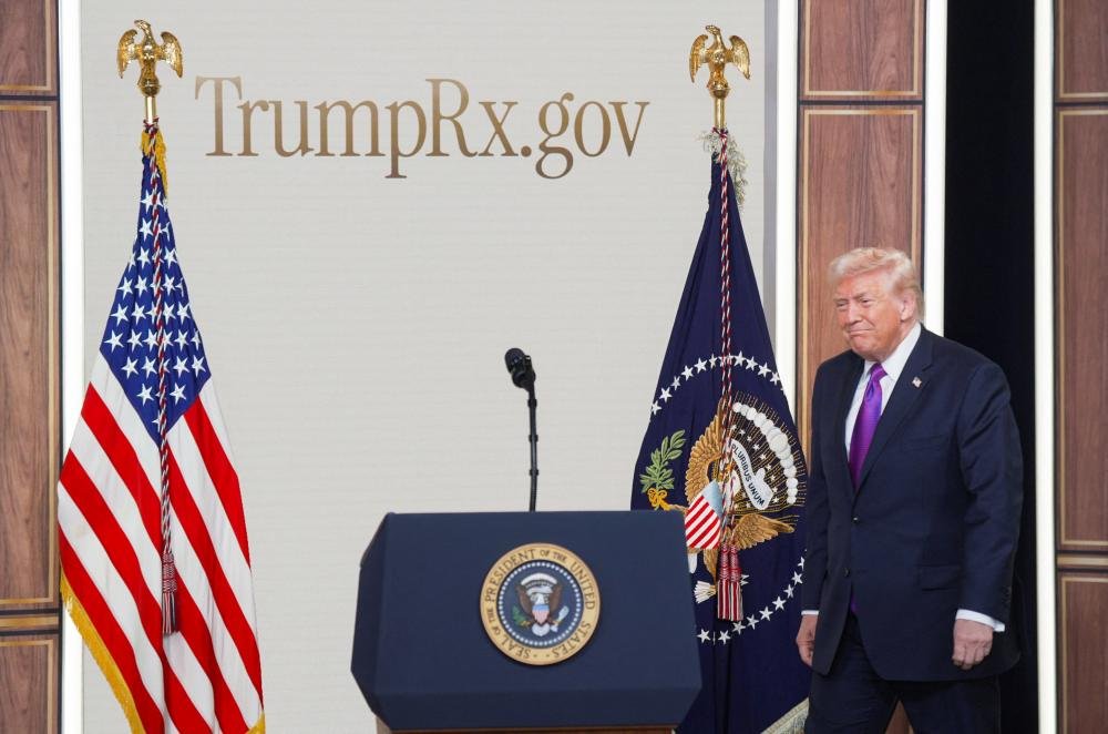 Donald Trump standing in front of a building with his name on it, symbolising his naming obsession and quest for immortality, with a cityscape in the background, highlighting the significance of this issue