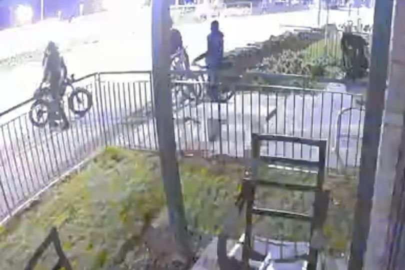 A group of e-bike riders gathered outside a residential area in Edinburgh at night, with the city's streetlights illuminating the scene, the primary keyword is e-bike gang