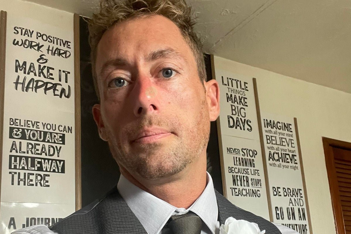A person holding a sign that reads 'Support for Domestic Abuse Victims' at a awareness campaign event, with a subtle background image of a broken chain, symbolising freedom from abuse, with the primary keyword 'domestic abuse' naturally included in the description
