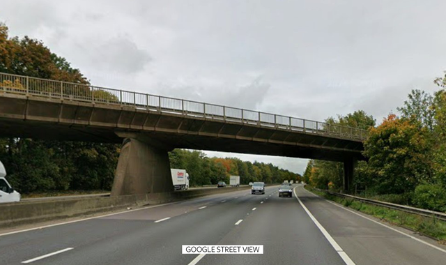 A car lies wrecked on the M1 motorway after falling off a bridge and crashing into a minibus, resulting in the tragic loss of two young lives in a devastating road accident on the M1