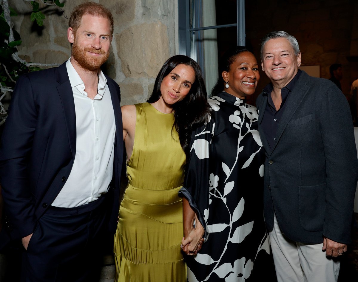 Meghan Markle attends event with Netflix boss and his wife, smiling and chatting with guests, surrounded by flashing cameras and media attention, with a focus on her latest public appearance and potential future collaborations with the streaming giant