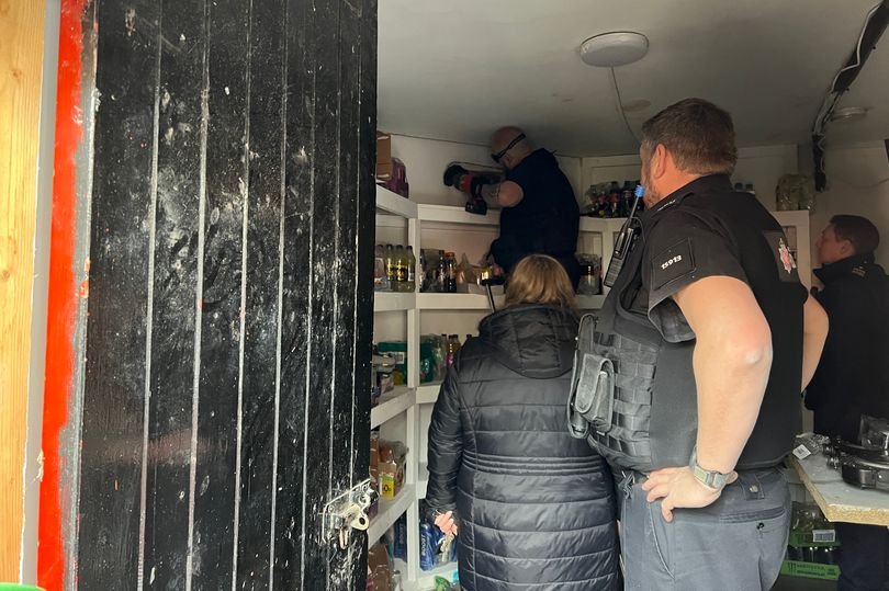 A photo of a biscuit aisle with a sign that says 'investigation ongoing' and a faint smell of sawdust in the air, with police officers and supermarket staff analysing the situation and trying to determine the cause of the unusual odour