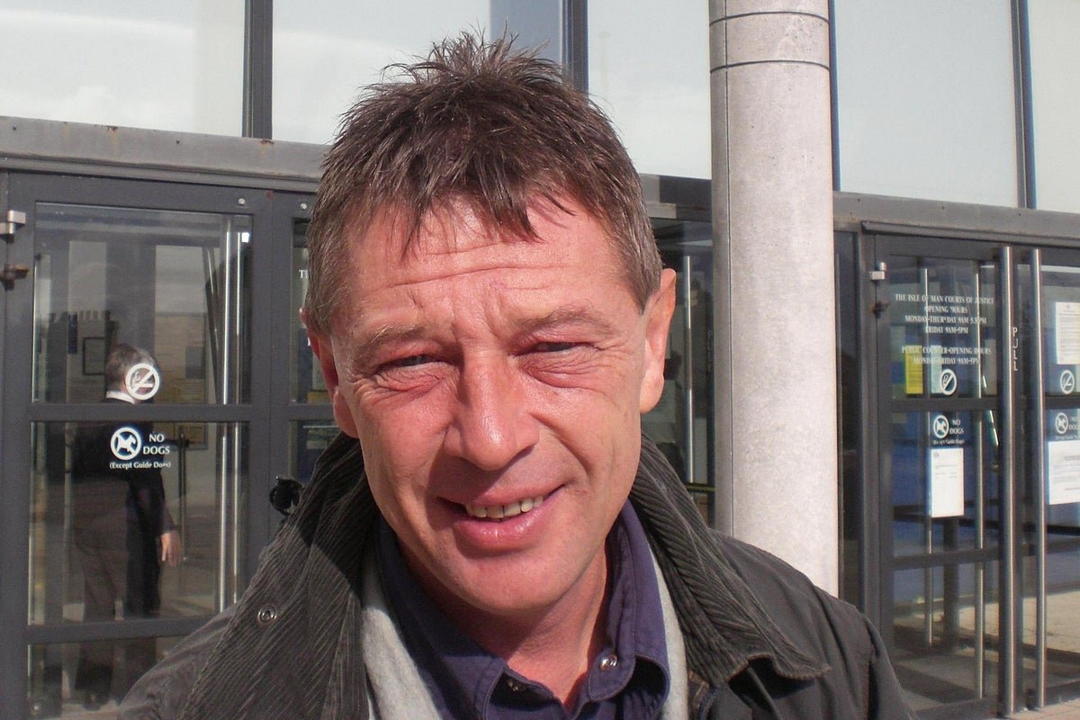 A photo of Andy Kershaw, a legendary Radio 1 DJ and Live Aid host, who has sadly passed away at the age of 66, leaving behind a legacy in the music industry with his unique style and charismatic behaviour, and will be deeply missed by his fans and fellow musicians