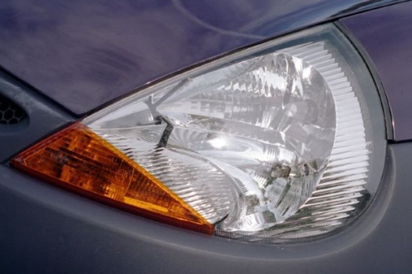 A car driving at night with properly aligned and clean headlights, highlighting the importance of headlight safety on UK roads