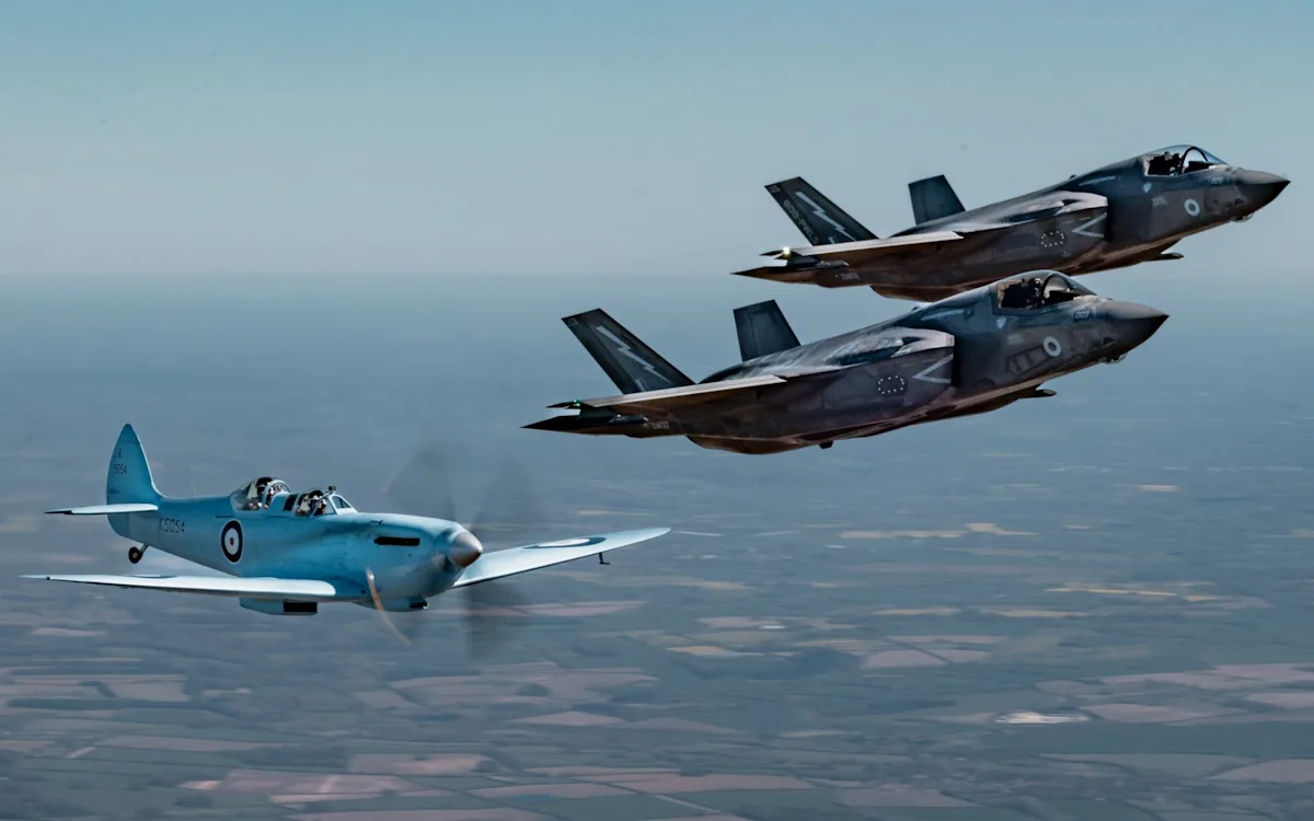 F-35 fighters and Spitfire flying together in a historic display of aviation, with the F-35 providing a modern escort to the vintage Spitfire, showcasing the evolution of aviation and the importance of preserving history, with the Spitfire's historic charm and the F-35's advanced technology on full display