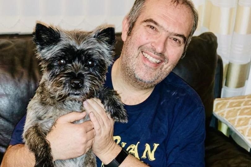 A dog being walked on a leash with its owner, highlighting the importance of pet safety and the risks of dog theft, with a focus on dog owners taking necessary precautions to protect their pets