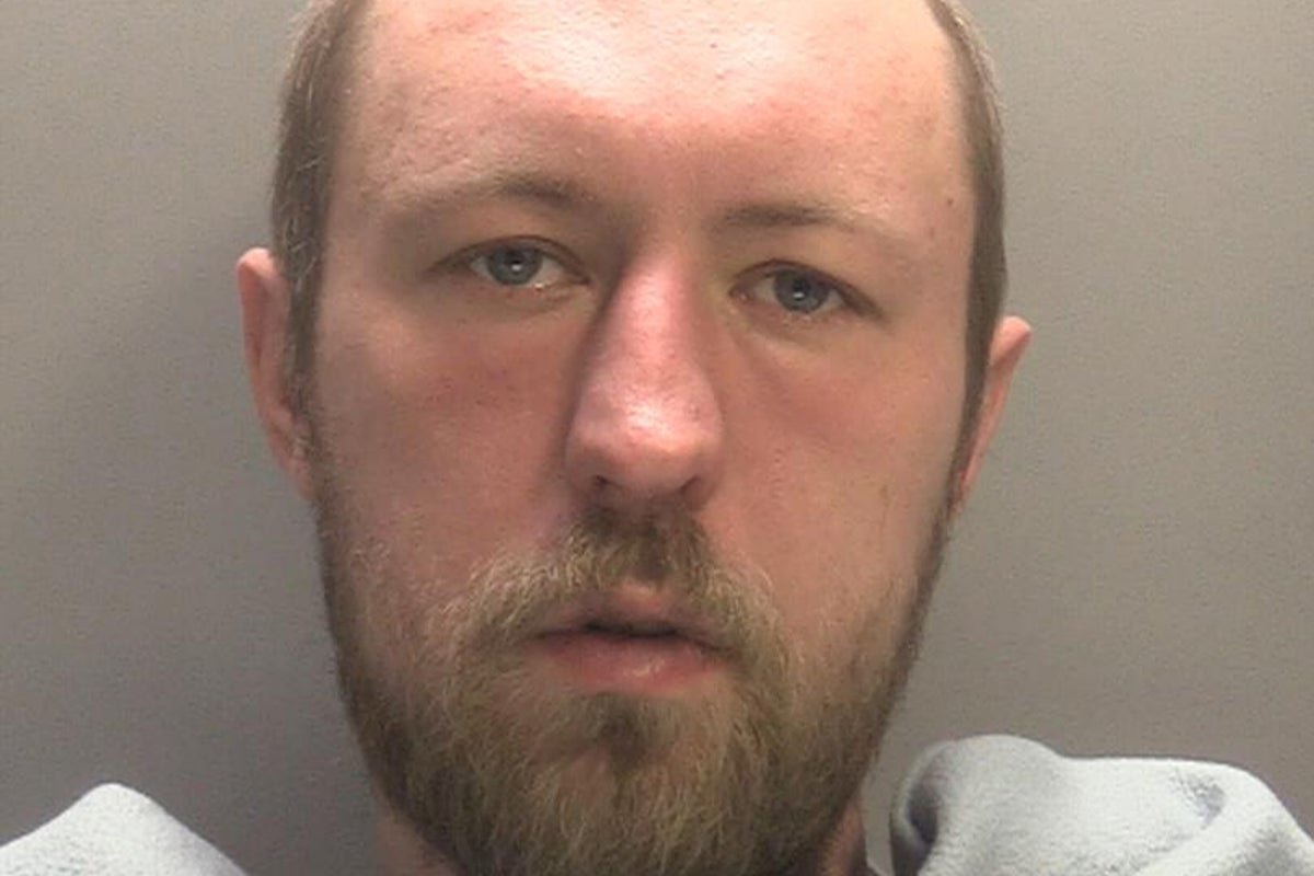 A Sikh woman holding a sign that reads 'Stop Hate Crimes' during a peaceful protest in Walsall, with a blurred background of people from different ethnicities and religions standing together in solidarity, highlighting the importance of promoting tolerance and respect for all religions and communities
