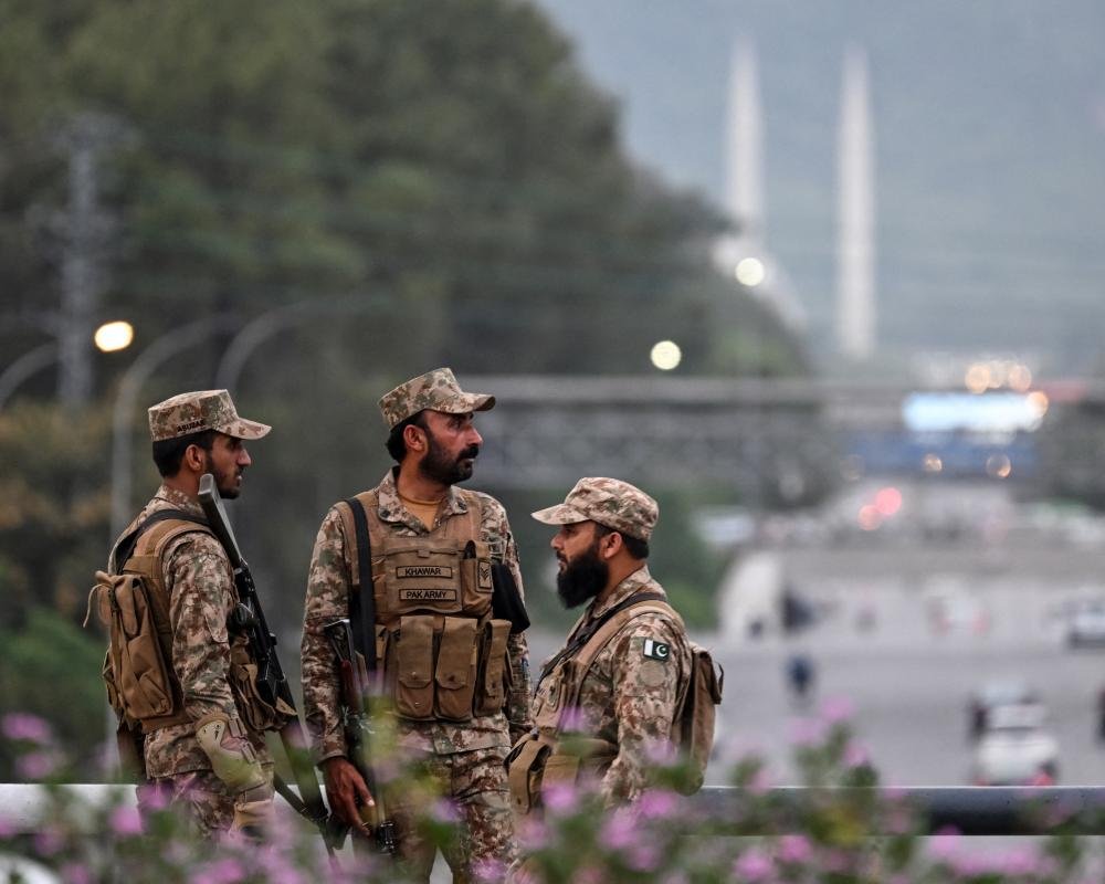 US and Pakistan flags waving together, symbolising diplomatic cooperation and peace efforts in the Iran war talks, with a backdrop of a cityscape in Pakistan, highlighting the colour and vibrancy of the region