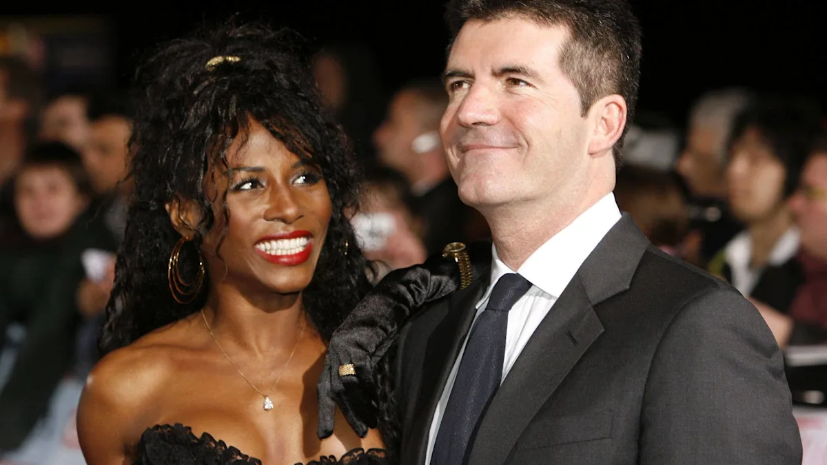 Sinitta and Simon Cowell together, smiling and embracing, with a backdrop of the entertainment industry, highlighting their 40-year romance and relationship