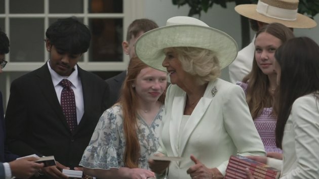 Queen Camilla and the First Lady handing out gifts to delighted youngsters, surrounded by colourful balloons and beaming smiles, highlighting the joy and excitement of the occasion, with a focus on royal gifts and kindness