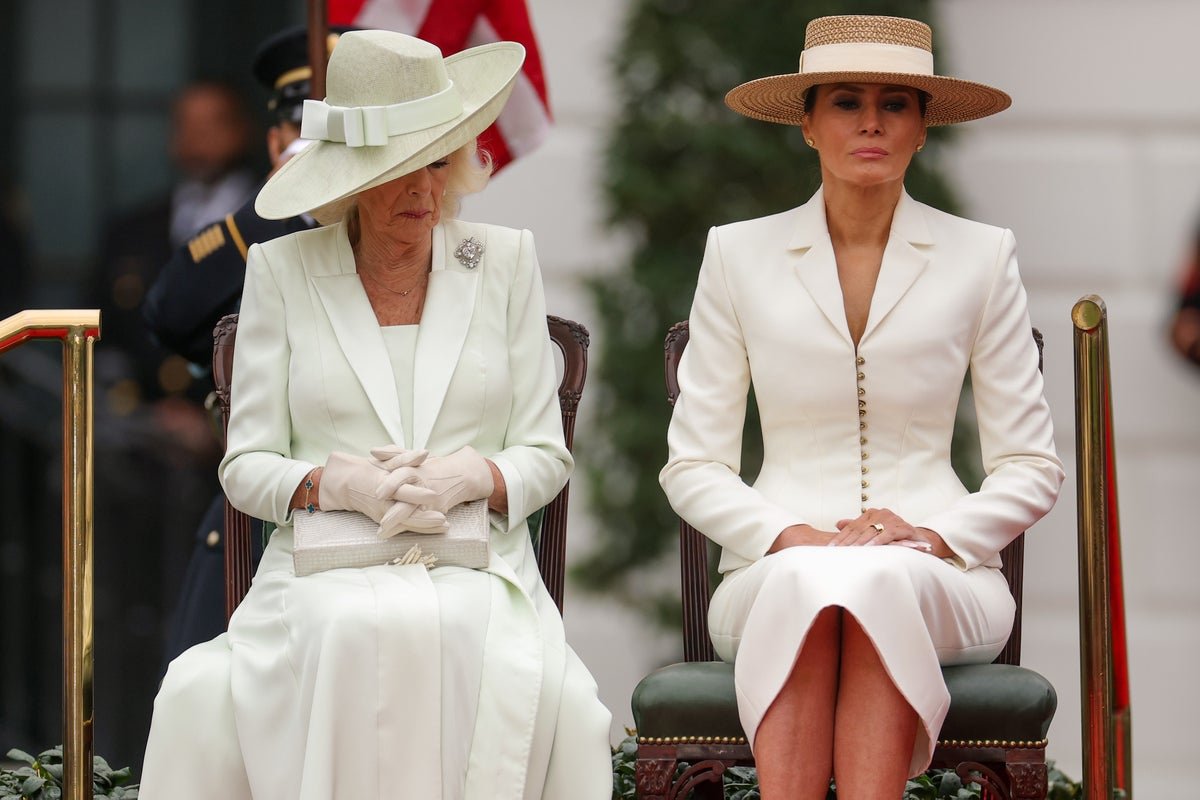 Donald Trump making a joke to Melania with King Charles in the background, a look of discomfort on their faces as they analyse the behaviour of the former US President, the colour of the scene is one of awkwardness and tension, a stark contrast to the usual laughter and applause that Trump receives, the primary keyword being Donald Trump's behaviour and social etiquette.