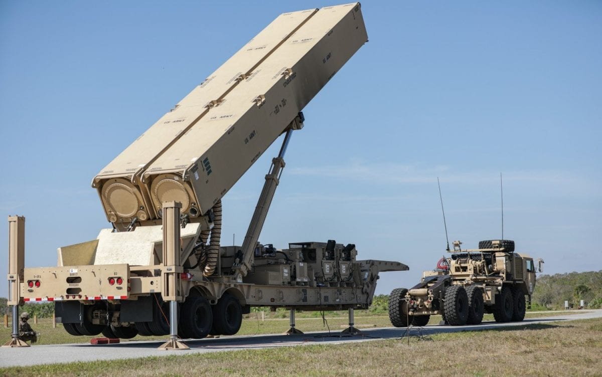 A US military personnel stands beside a Dark Eagle hypersonic missile system, with a desert landscape in the background, symbolising the US military presence in the region and the primary keyword hypersonic missiles