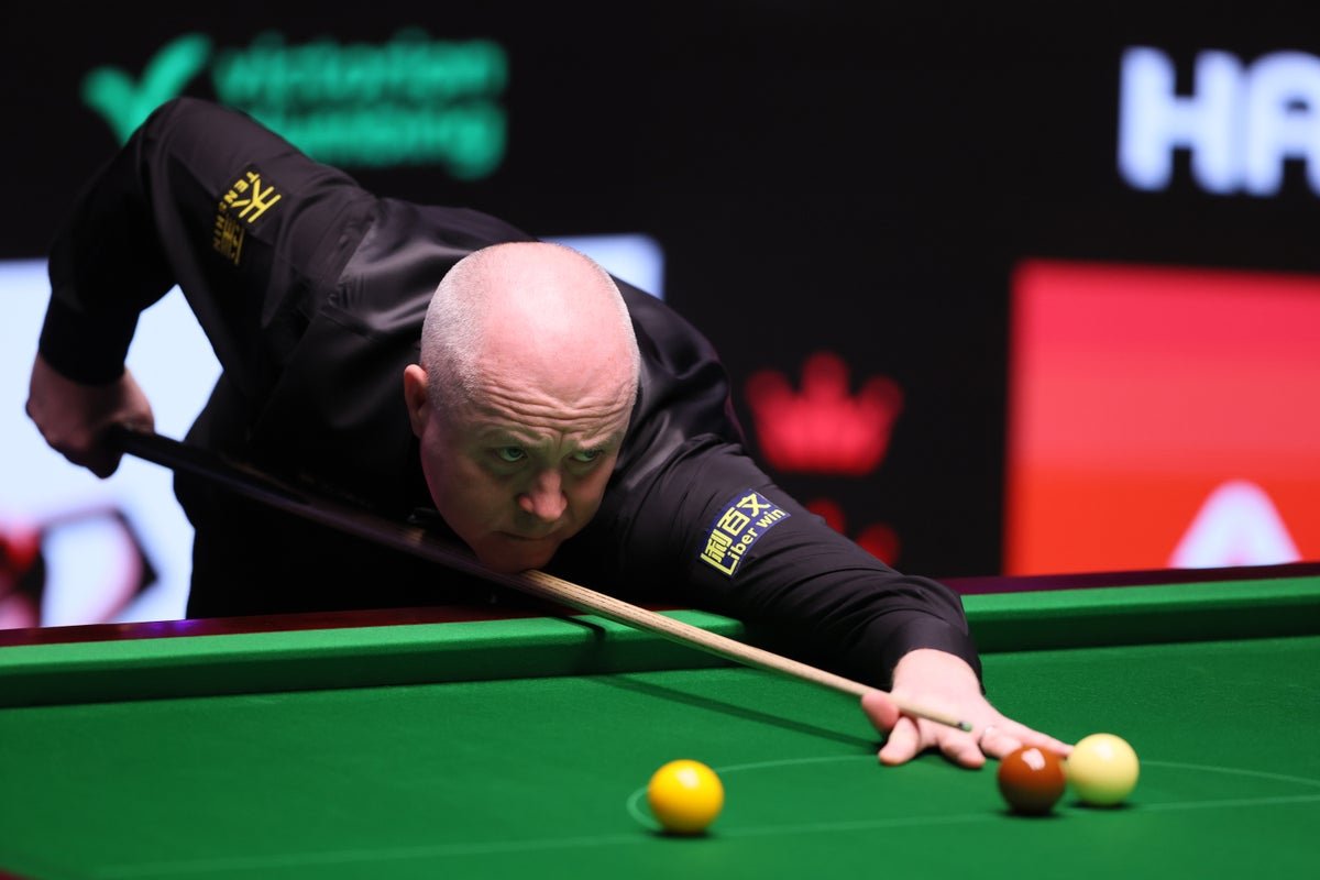 A photo of John Higgins in action, showcasing his focus and skill as he lines up a shot, demonstrating his expertise and technique in the game of snooker, with a crowd watching in the background, highlighting the excitement and colour of the sport