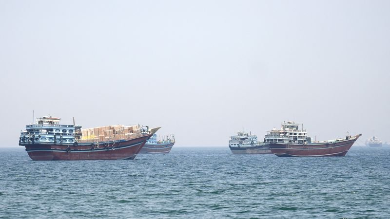 Iran's flag waving in the wind, symbolising the nation's resolve in the face of US pressure, with a complex geopolitical situation unfolding in the background, as the international community watches with bated breath
