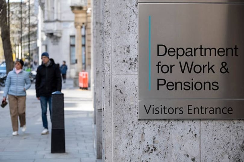 A person holding a benefit claim form, with a concerned expression, as the DWP considers scrapping a benefit claimed by 1.4 million people, with a background of UK government buildings, highlighting the impact on claimants and the need for reform