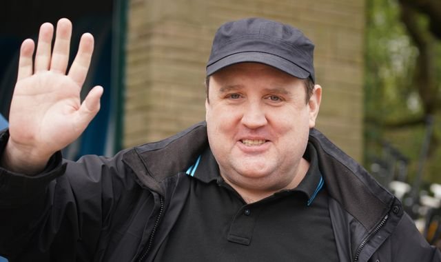 Peter Kay on stage with a concerned expression, with a blurred audience in the background, highlighting the primary keyword 'suspicious bag'