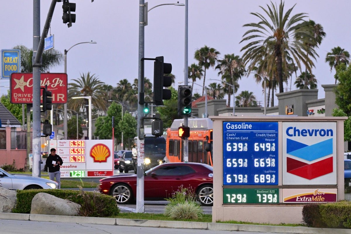 A photograph of a petrol station with a sign displaying high fuel prices, highlighting the impact of rising petrol costs on daily life and the need for sustainable transport solutions