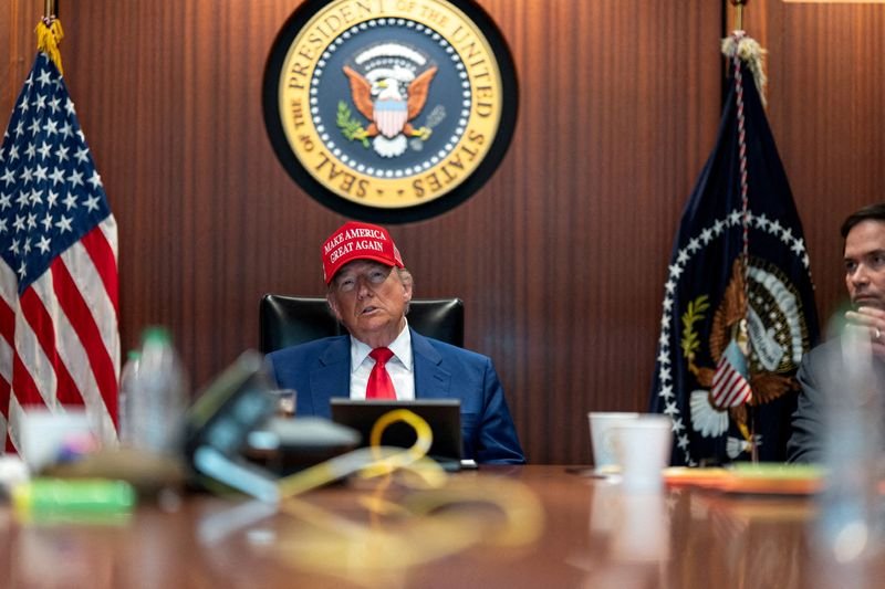 A picture of the Iranian flag and the US flag, symbolising the tense relations between the two countries, with a focus on the Iran standoff and its potential consequences, including a war with Iran