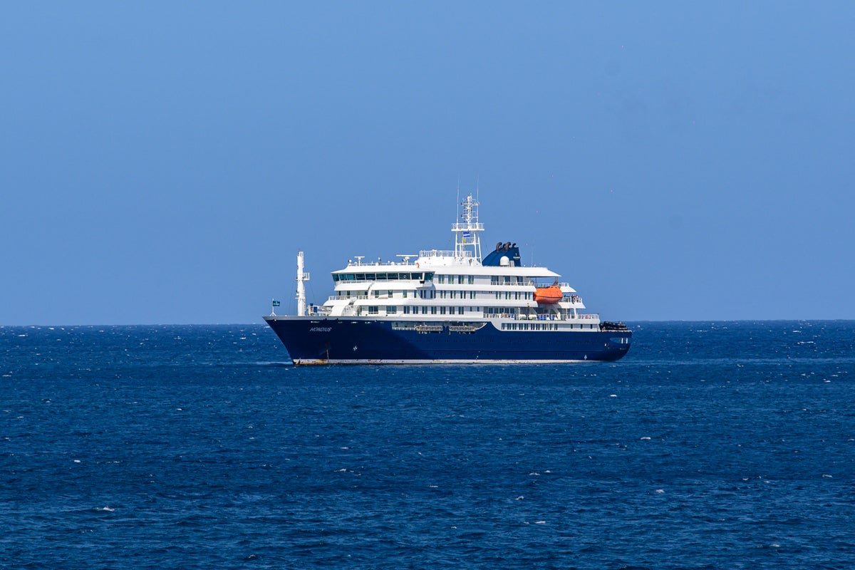A photo of a polar expedition ship in the icy waters of the polar regions, with a group of tourists and crew members on board, highlighting the risks of hantavirus transmission in such areas
