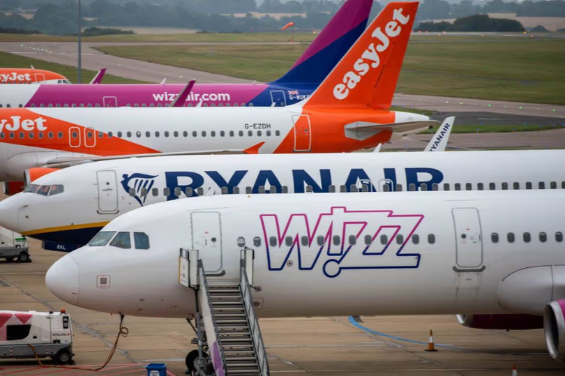 Aircraft flying in the sky with a warning sign, fuel crisis deepens, flight booking warning, Ryanair, Jet2, easyJet, £100 extra costs, aviation industry affected