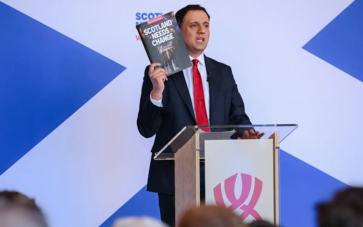 A crowd of people protesting in the streets, holding signs that read 'Trans Rights Are Human Rights' and 'Equality For All', as the Scottish Labour party's decision to back the trans ban sparks controversy and debate, with the primary keyword being trans ban