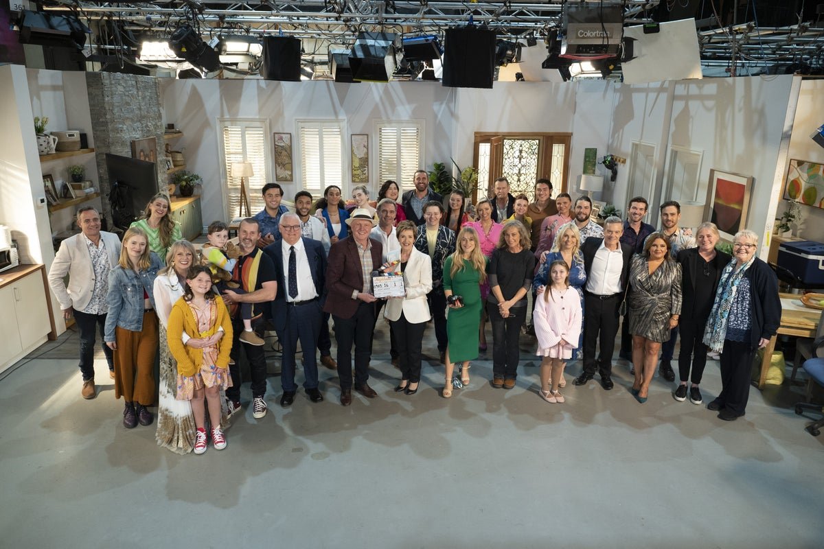Neighbours soap opera finds new home in the UK after Amazon Freevee cancellation, featuring a photo of the show's cast and crew, with a mix of excitement and relief on their faces, as they look forward to a new chapter in the show's history, with a colourful background and a sense of anticipation in the air