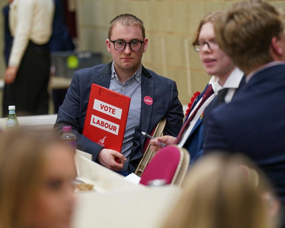 A descriptive image of a polling station in England, with voters casting their ballots in the local elections, highlighting the primary keyword of England local elections