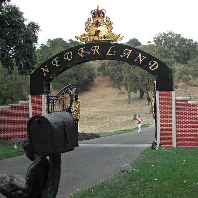 Aerial view of Michael Jackson's Neverland Ranch, featuring lush gardens, exotic animals, and a theme park, showcasing the King of Pop's love for colour and design, with a focus on the primary keyword phrase 'Neverland Ranch'