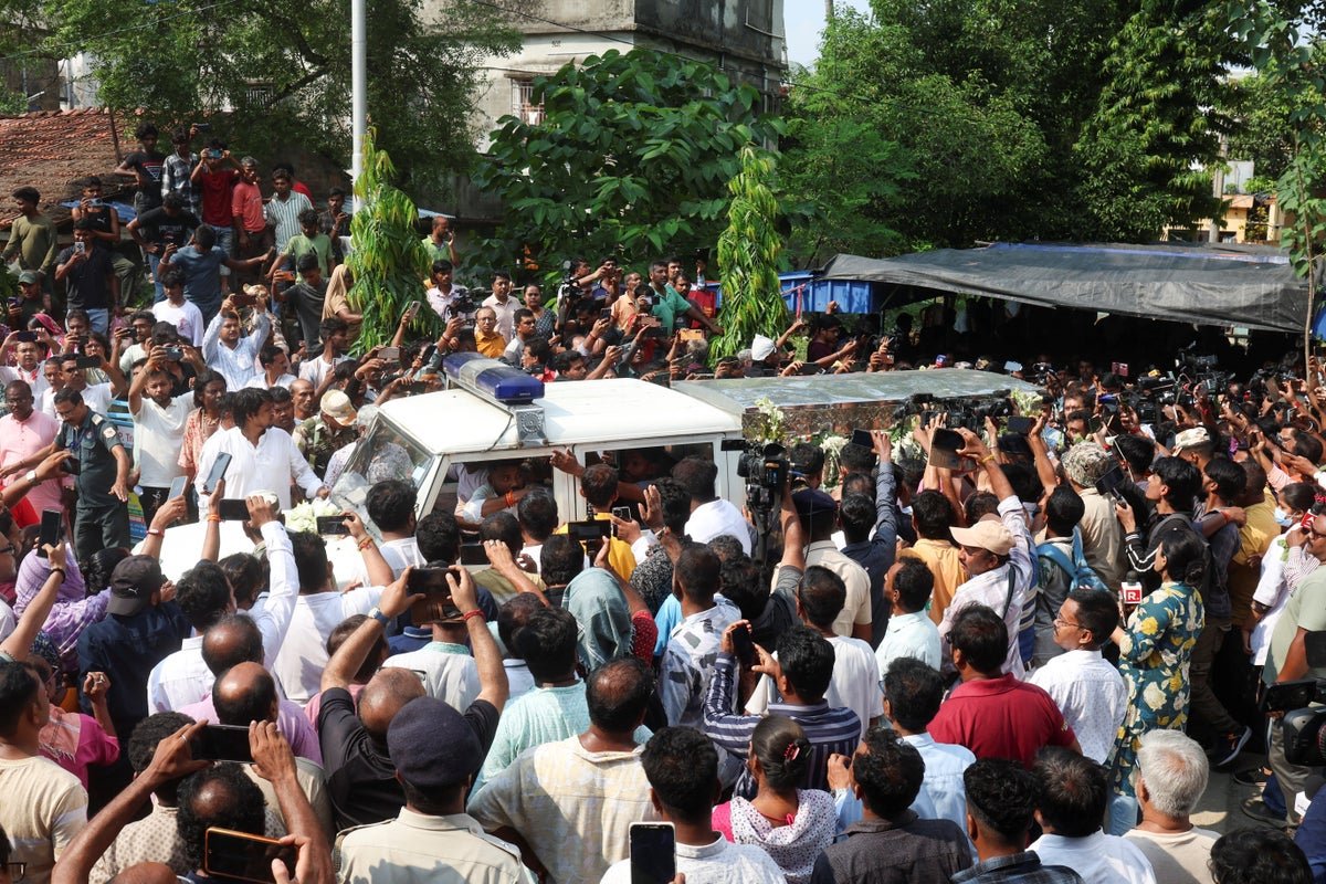 A crowd of protesters in India, with police in the background, highlighting the unrest and violence in the country, with a focus on the India unrest keyword