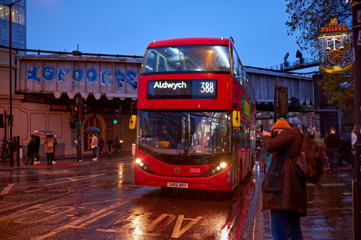 A descriptive image of a London bus with a Hopper package logo, highlighting the new fare system and its benefits for commuters, with a London street scene in the background, showcasing the city's transport network and its commitment to sustainable transport