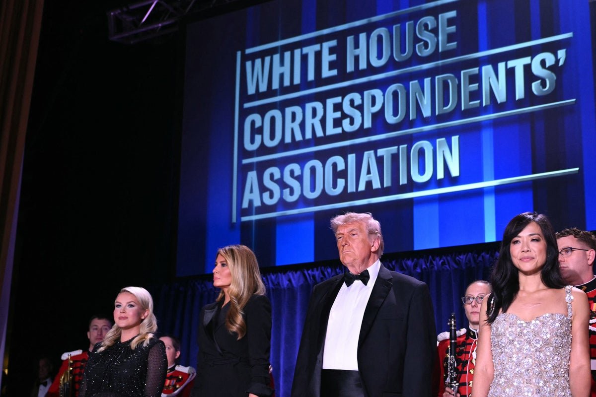 A photo of the White House Correspondents' Dinner, with a crowd of people in the background, and a sense of uncertainty and speculation in the air, as many wonder if the assassination attempt was real or staged