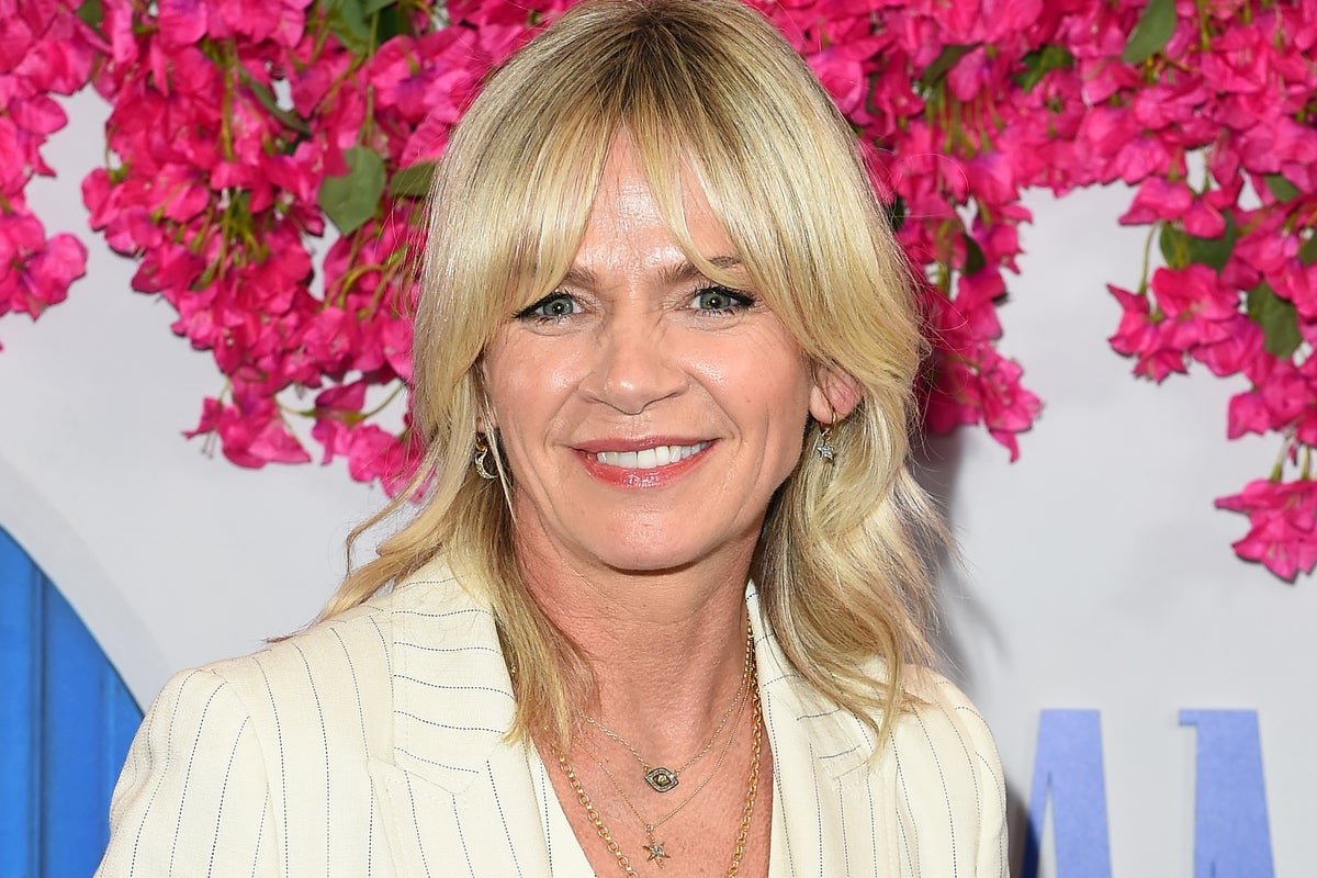 Zoe Ball smiling and posing for a photo, surrounded by glittering Strictly Come Dancing trophies and costumes, with a caption that reads: 'Zoe Ball: A Beloved TV Personality'