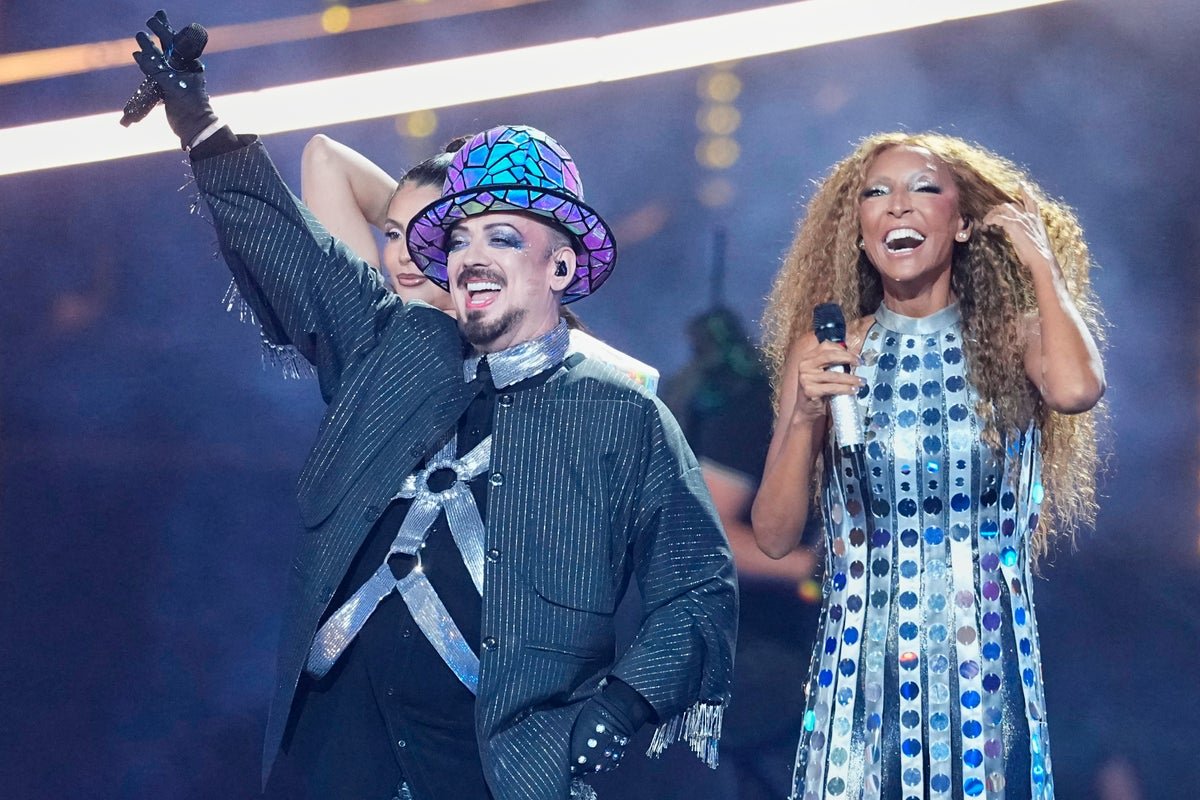 Boy George performing on the Eurovision stage with Jimmie Allen, representing San Marino, with a crowd of excited fans in the background, waving flags and cheering, the atmosphere is electric, with a mix of colour and music, the perfect blend of entertainment and culture