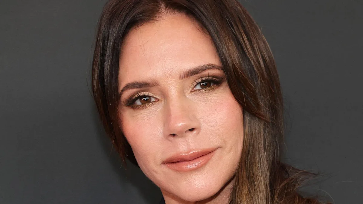 Victoria Beckham and son Brooklyn Beckham attend a celebrity event, with Victoria looking stylish in a black dress and Brooklyn wearing a suit, the two are smiling and posing for photos, with a crowd of people in the background, the atmosphere is lively and colourful, with a focus on the celebrity mother and son