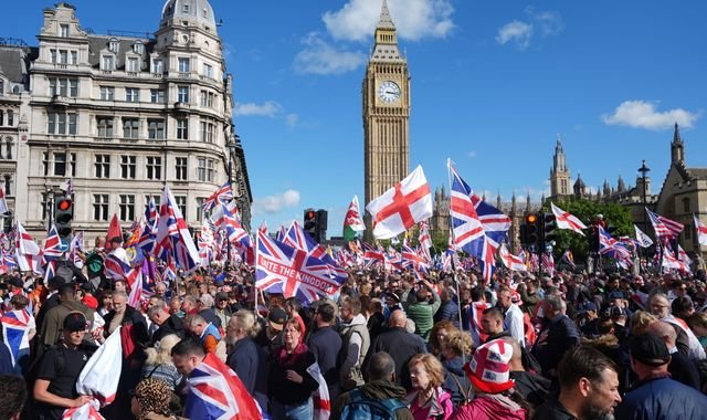 A large crowd of protesters holding signs and banners, with a focus on the Unite the Kingdom and pro-Palestine rallies in London, demonstrating for social justice and human rights