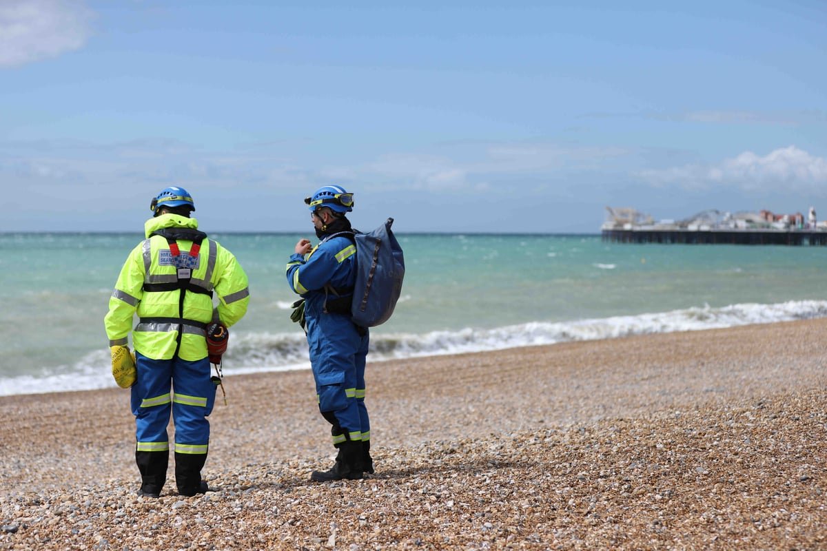 Aerial view of Brighton beach, with a steep drop and a warning sign, highlighting the importance of beach safety and being aware of one's surroundings, with the primary keyword phrase 'Brighton beach tragedy' associated with the incident