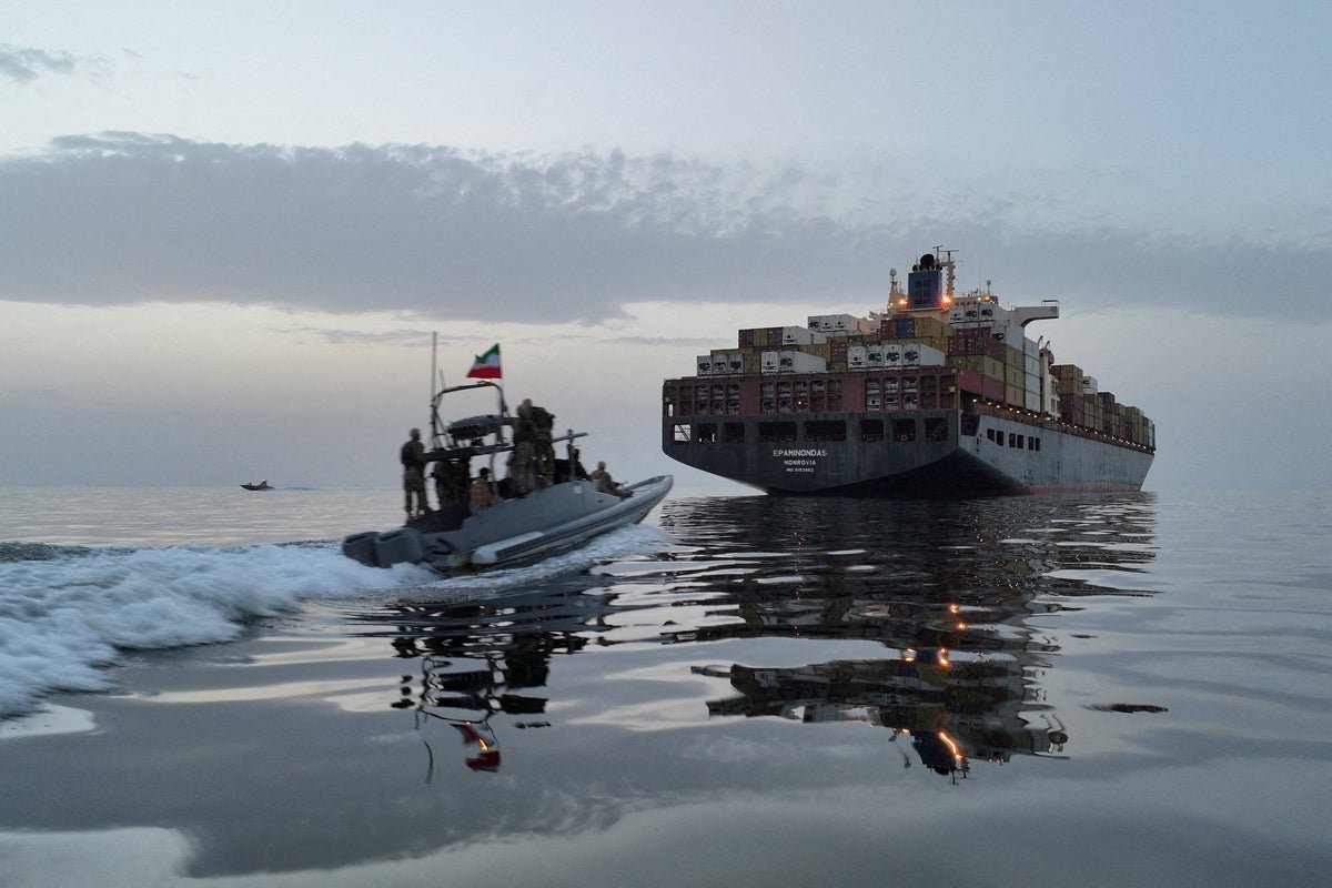Aerial view of the Strait of Hormuz with ships passing through, symbolising the importance of this waterway for global trade and the need for the UK-led mission to secure it