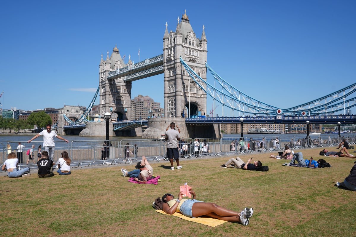 A descriptive image of a sunny day in the UK, with people enjoying the warm weather and sunshine, perfect for a bank holiday weekend, with a focus on UK weather and temperatures
