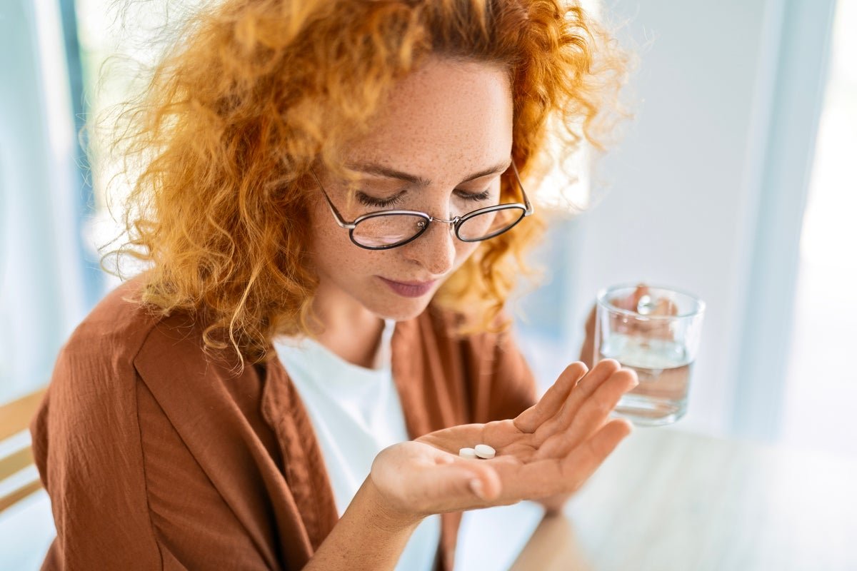A person holding a pill bottle with a hopeful expression, symbolising the new hope offered by the arthritis drug in treating depression, with a subtle background colour of blue, representing calmness and serenity, and a gentle glow, signifying the positive impact of this breakthrough