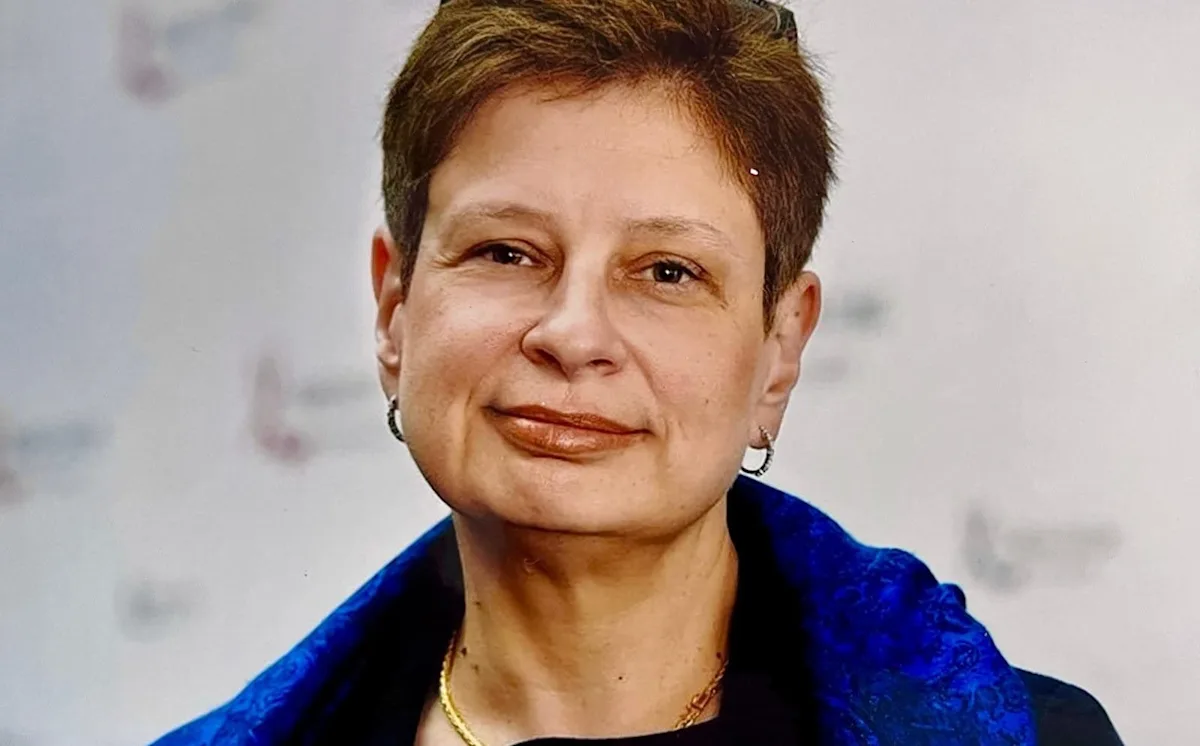 A photo of a person holding a sign that reads 'Freedom for Russia' with a backdrop of the Russian flag, symbolising the ongoing struggle for democracy and human rights in the country, with a focus on the enemy of the state label