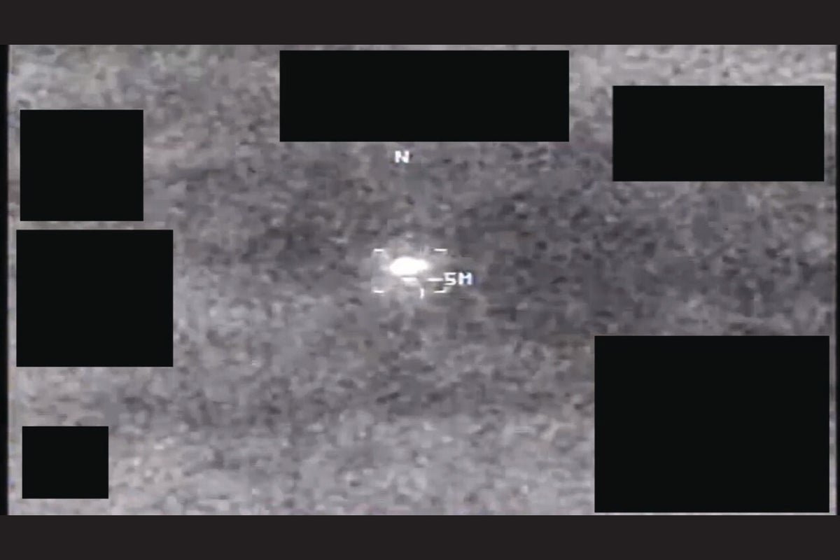 A photo of a UFO sighting, with a bright orb-like object in the sky, taken by an intelligence officer. The image shows a strange, glowing object hovering above the trees, with a few stars visible in the background. The orb is a type of UAP that has been observed in various parts of the world, and its behaviour and colour have been studied by researchers.