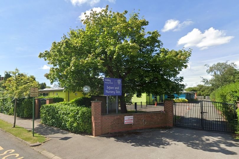 A man standing near a school gate, staring inappropriately at children, with a concerned parent in the background, highlighting the importance of child safety and suspicious behaviour awareness