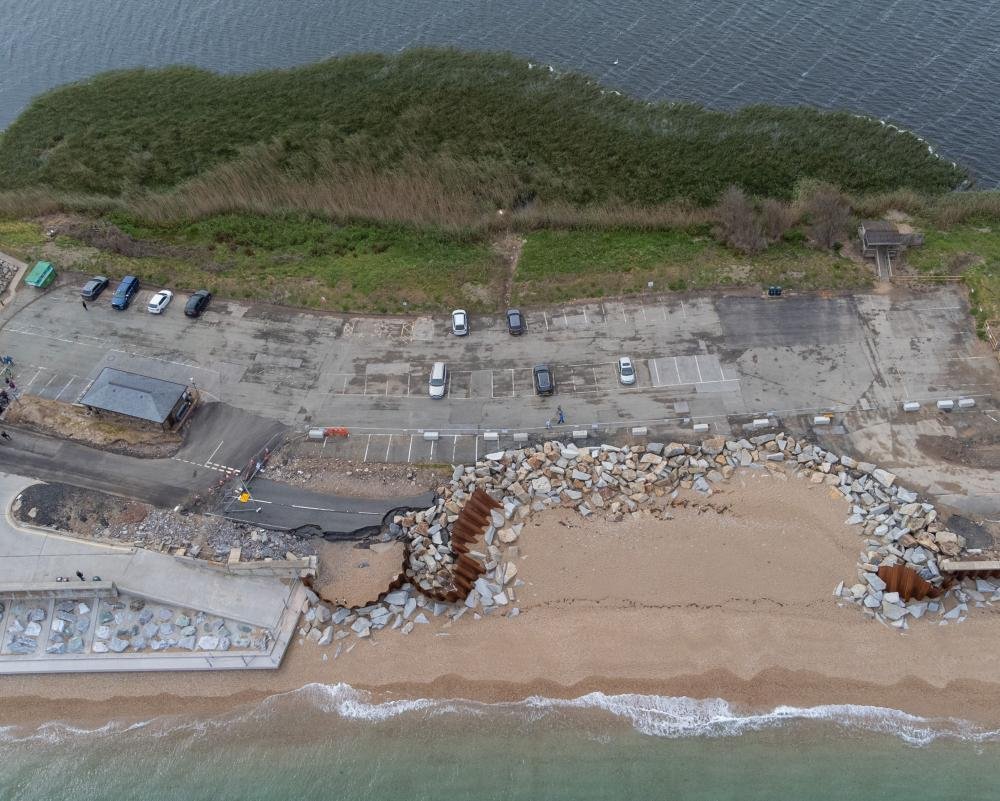 Aerial view of the UK coastline, with homes and infrastructure threatened by rising sea levels and coastal erosion, a consequence of climate change and a pressing concern for the environment and local communities