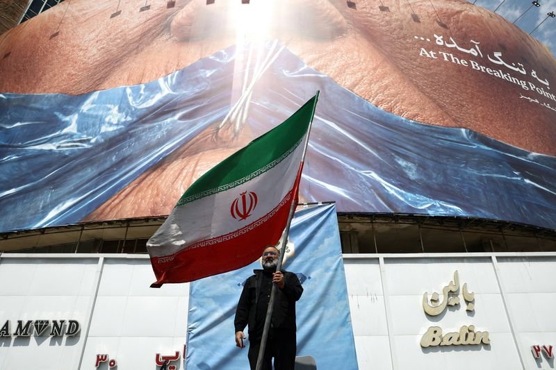 Iran and US flags in the background with a silhouette of a person in the foreground, symbolising the complex and sensitive nature of the conflict between the two nations, with a potential breakthrough in the war between Iran and US