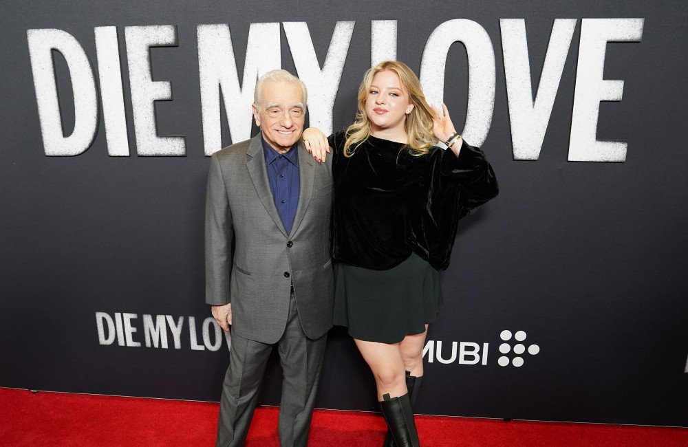 Francesca Scorsese, daughter of Martin Scorsese, smiles confidently as she walks the red carpet, ignoring the haters and focusing on her craft, with a bright colour and a beautiful background, showcasing her unique style and behaviour